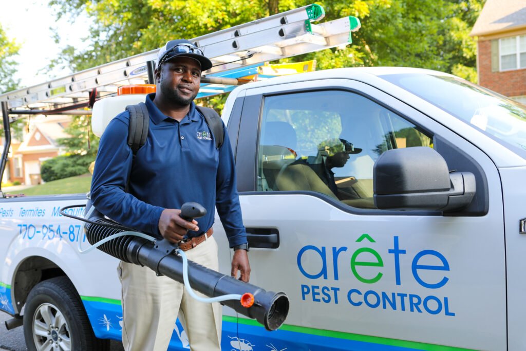 Pest control technician applying treatment in a residential area.